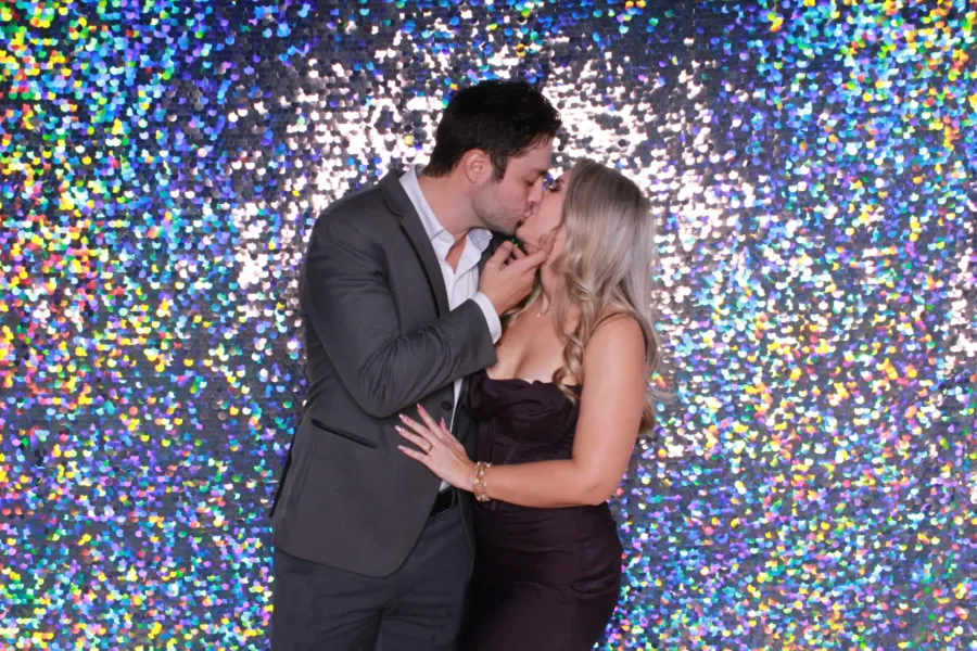 Couple kissing in front of backdrop